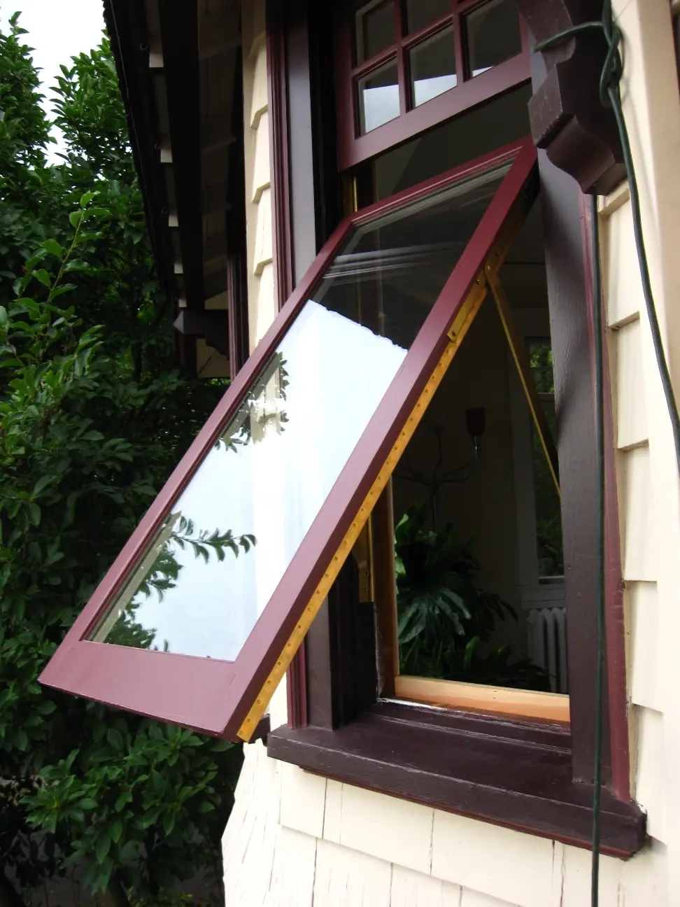 Awning-hung wood sash tipped open from the bottom
