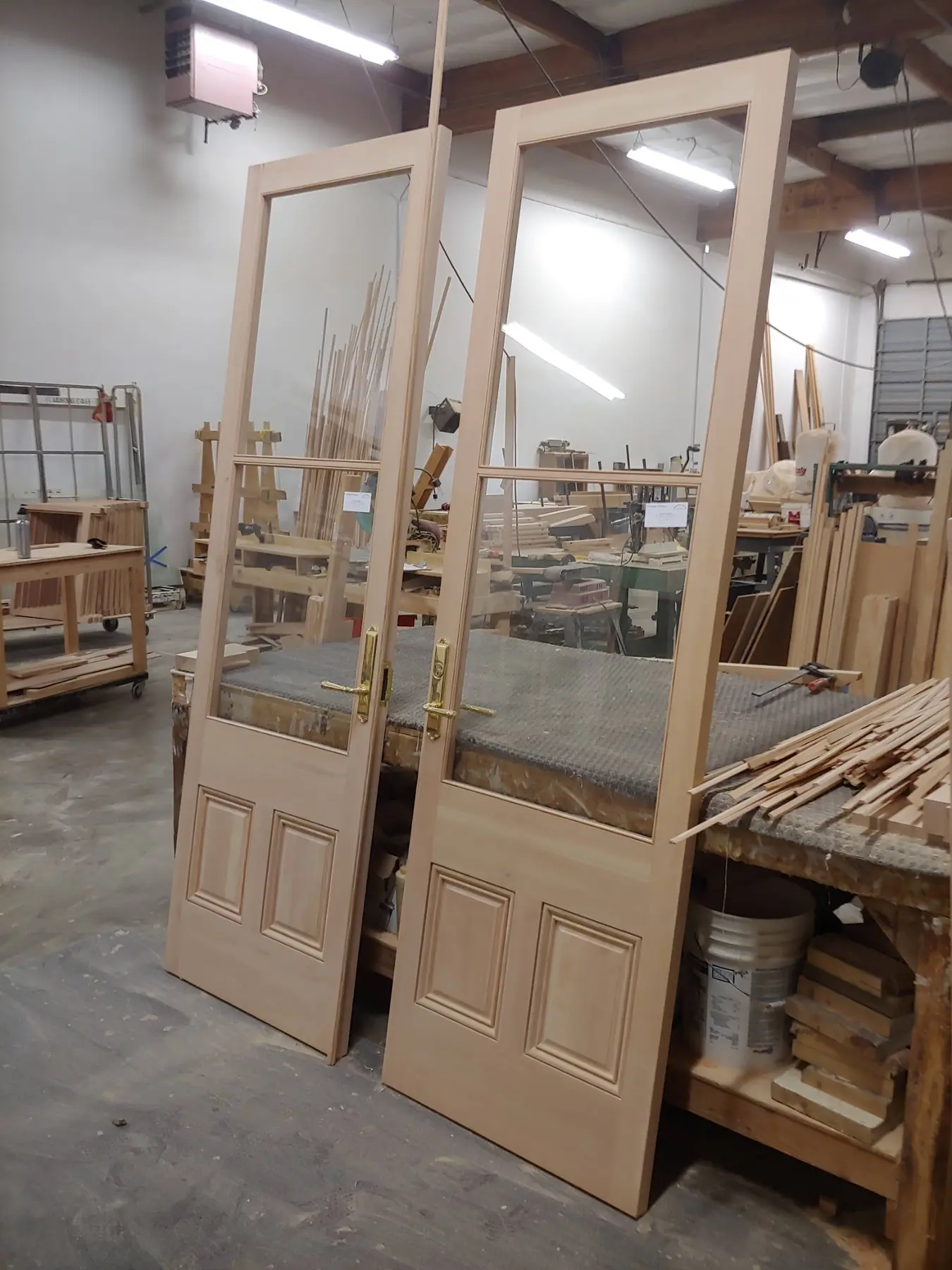 Pair of custom wood doors standing in the Wooddale shop