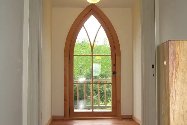 Custom pointed-arch wood entry door with divided lites