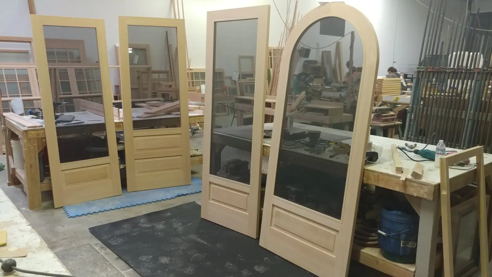 Several custom wood screen doors, including an arched door, in the Wooddale shop