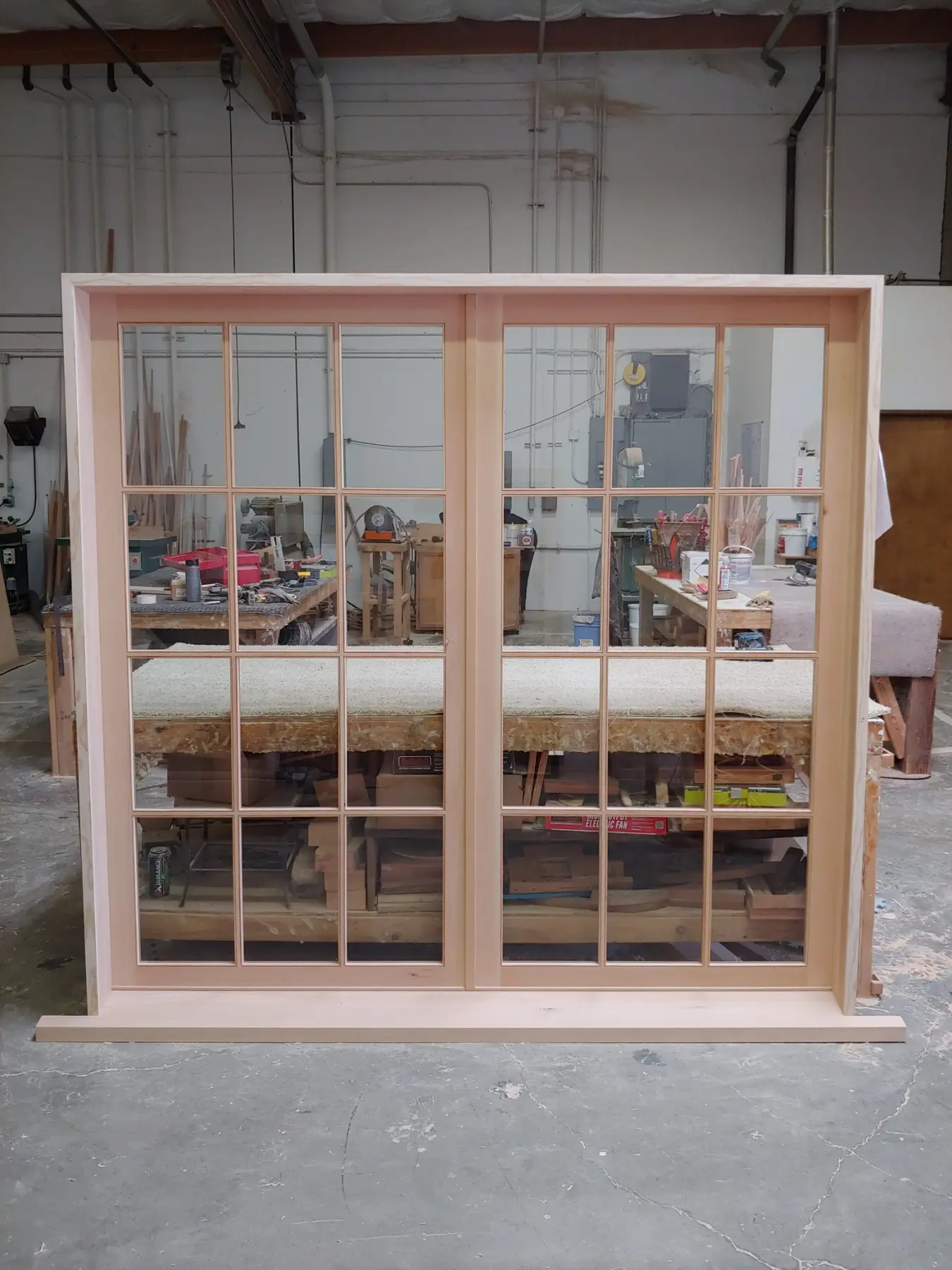 Pair of divided-lite custom wood windows in the Wooddale shop