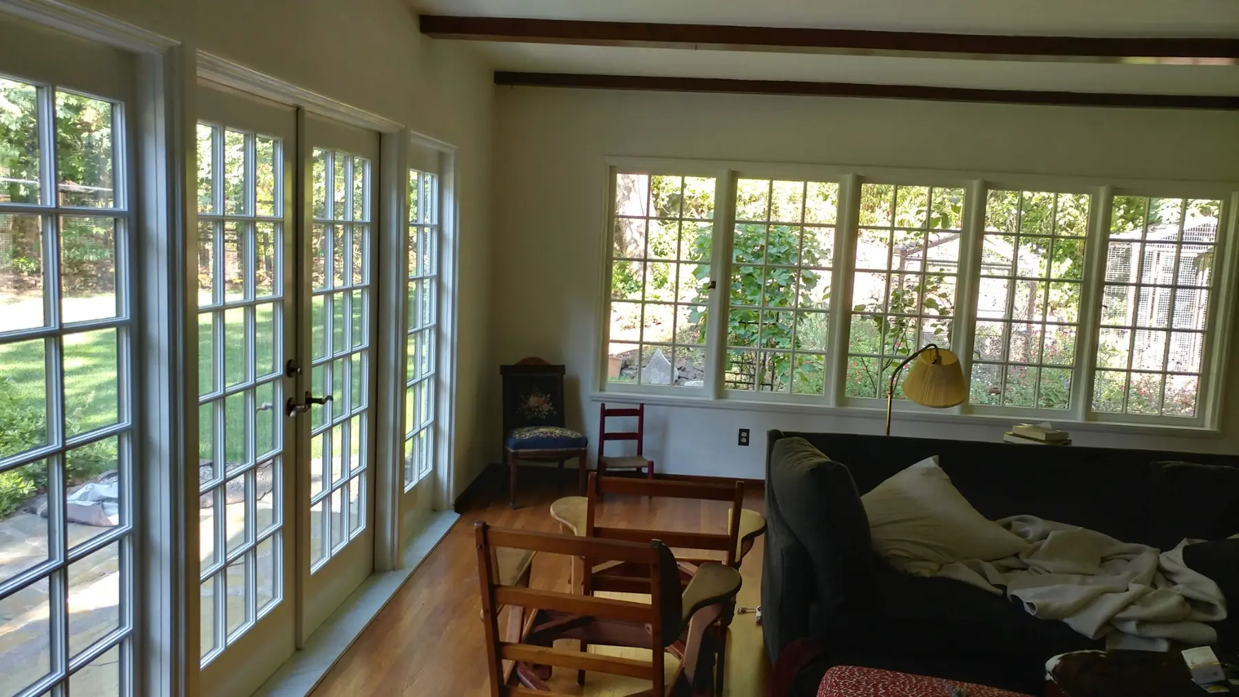 A finished room lined with custom divided-lite wood windows and doors