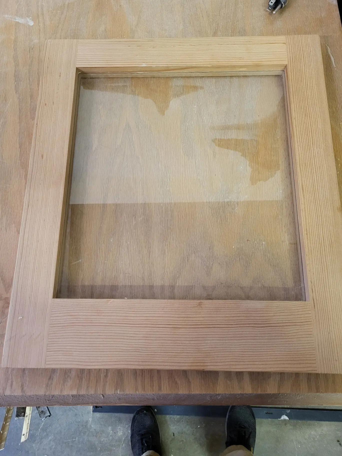 Interior face of the same unfinished wood glass storm sash on the workbench